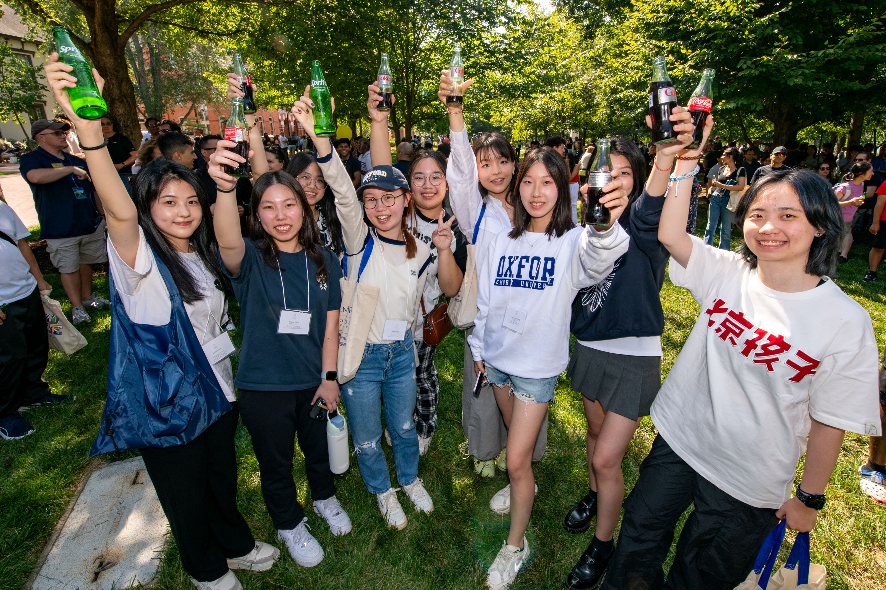 A group of iMentor students smiling while holding Coke bottles