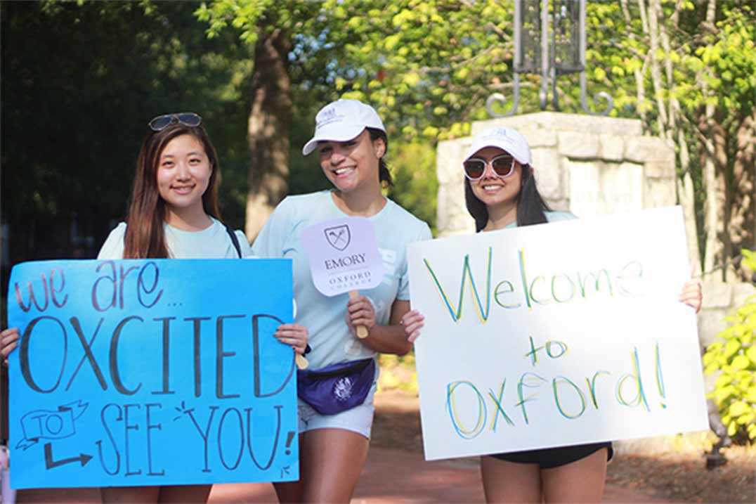 Students holding welcome signs at move in 